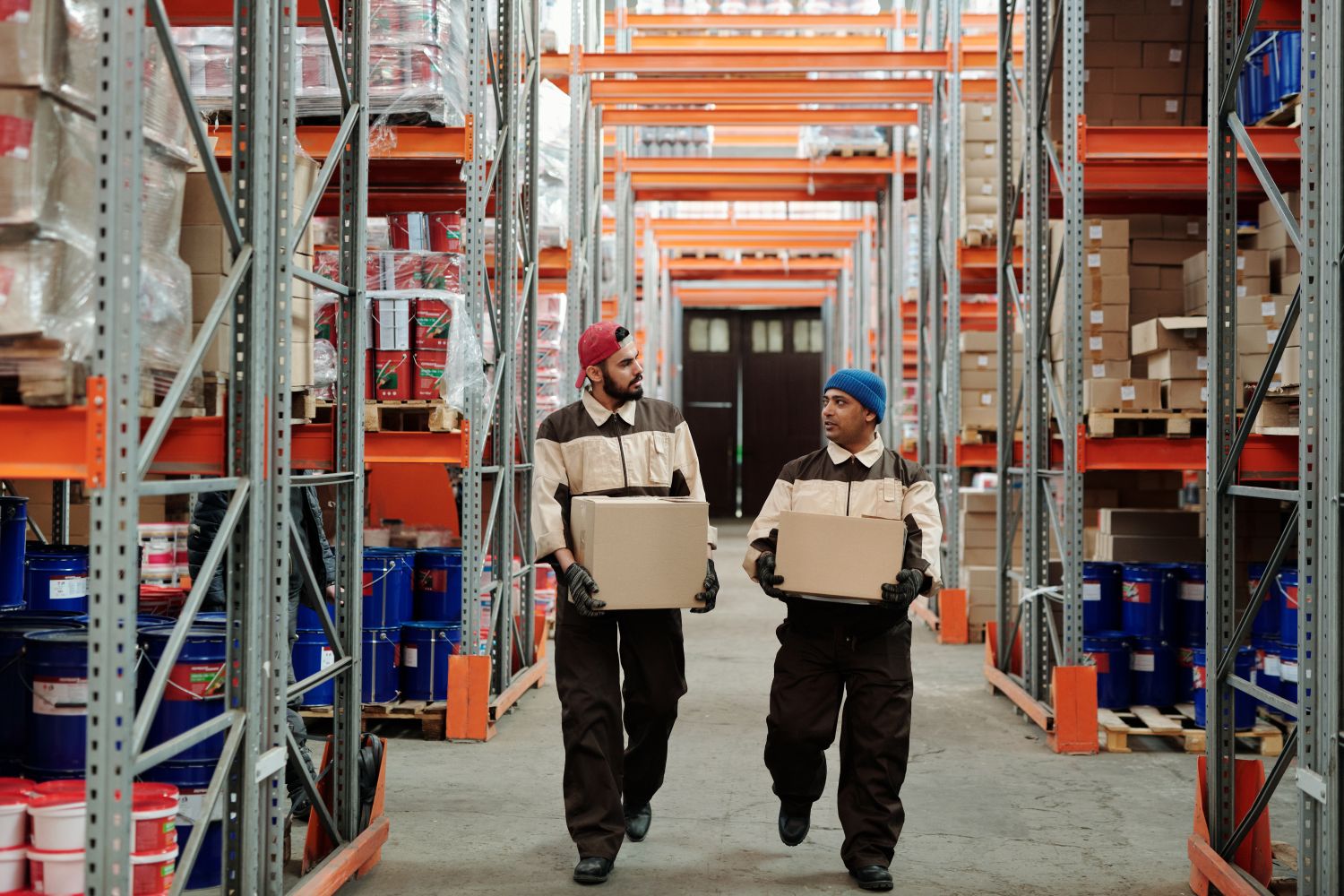 Trabajadores transportando cajas en un almacén.